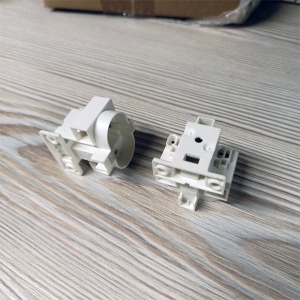 Патрон G23 для компактных люминесцентных ламп с центральным креплением под винт М3 и боковыми креплениями под винт М4.