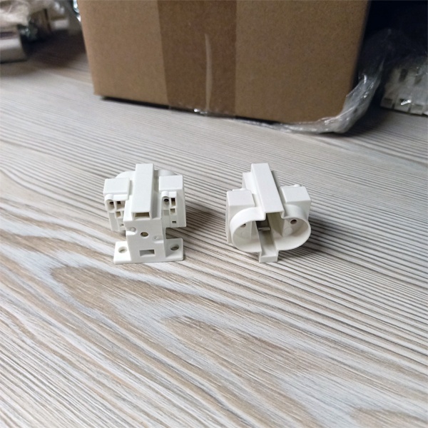 Патрон G23 для компактных люминесцентных ламп с центральным креплением под винт М3 и боковыми креплениями под винт М4.